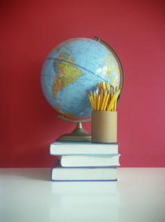 Still life of books, pencils, and globe.