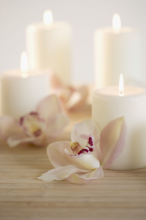 Still life of orchids and candles.