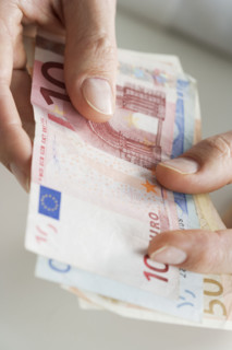 Closeup of hands with European money.
