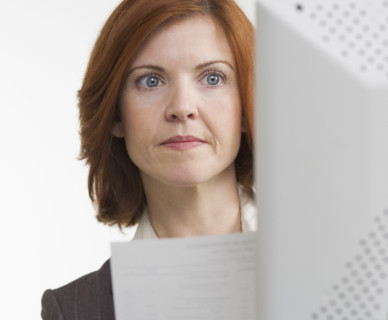 Woman at computer with paper.