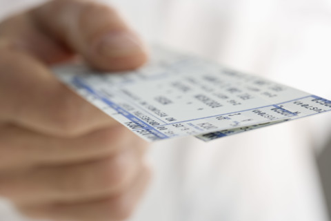 Closeup of hand holding tickets.