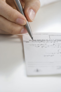 Closeup of hand writing prescription.