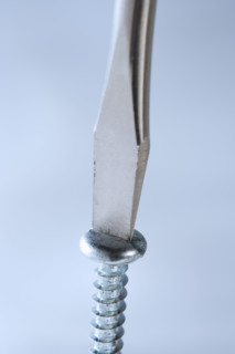 Closeup of screwdriver and screw.