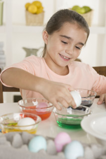 Girl coloring Easter eggs.