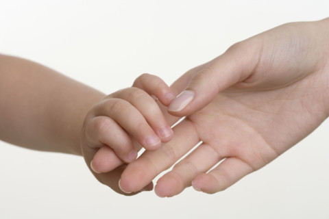 Baby holding hands with mother.
