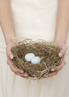 Female holding nest with eggs.