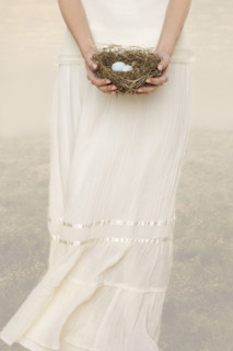 Female holding nest with eggs.