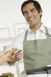 Shopkeeper taking credit card.