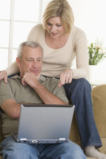 Couple using laptop computer at home.