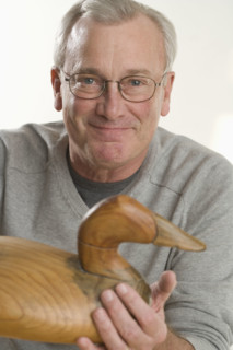 Man holding handmade wooden duck.