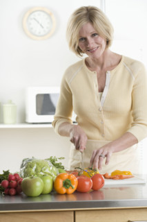 Portrait of woman cutting vegetables.