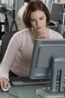 Woman working at computer in office.