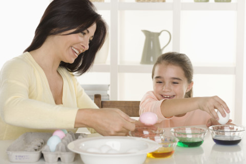 Mother and daughter coloring Easter eggs.