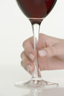 Female hand holding glass of wine.