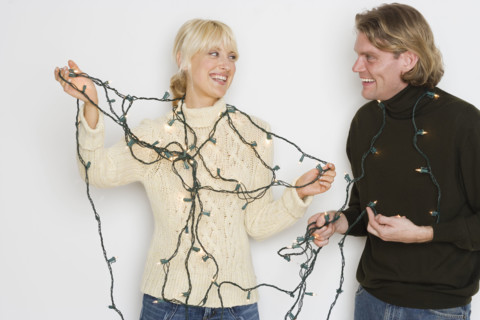 Couple untangling holiday lights.