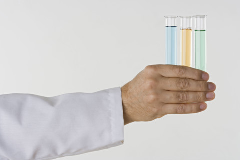 Hand holding test tubes.