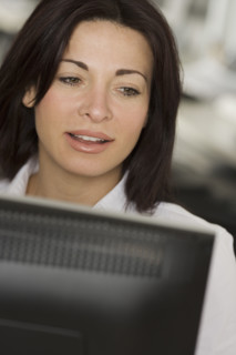 Woman in office looking at computer screen.