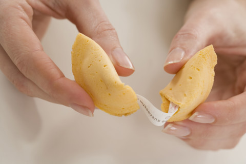Woman breaking fortune cookie.