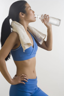 Woman drinking bottled water after workout.