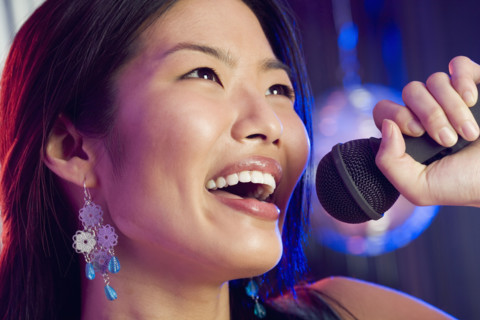 Woman singing into microphone.
