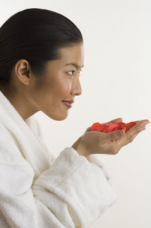 Woman smelling rose petals.
