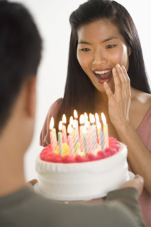 Woman presented with surprise birthday cake.