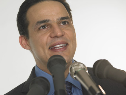 Man speaking into microphones.