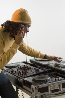 DJ working at music mixing board.