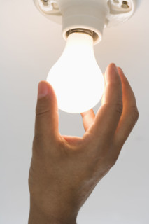 Close up of lightbulb being screwed in .