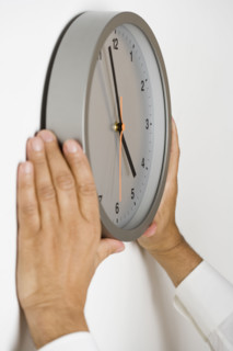 Close up of clock being put on wall.