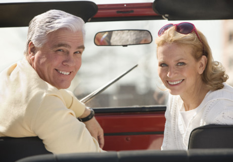 Senior couple sitting in jeep.