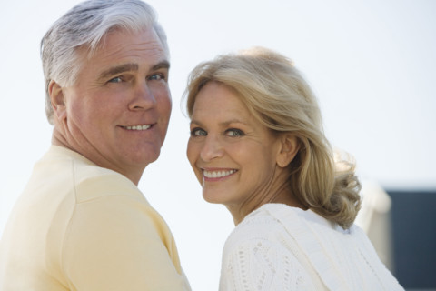 Senior couple smiling outdoors.