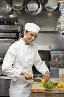 Female chef in restaurant kitchen.