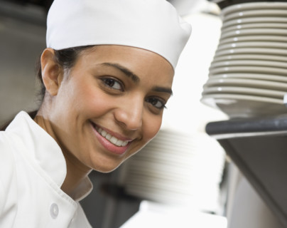 Female chef in restaurant kitchen.