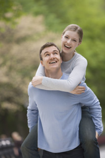 Boyfriend giving girlfriend piggyback ride.