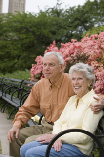 Senior couple sitting on park bench.