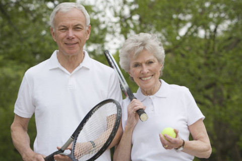 Portrait of mature couple with tennis racquets.