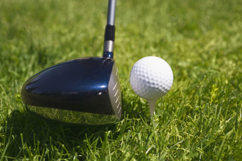 Closeup of golf ball teed up for play.