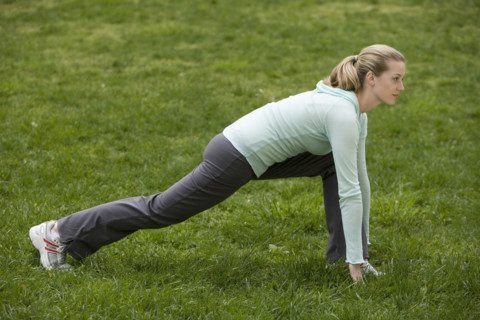 Woman stretching in park.