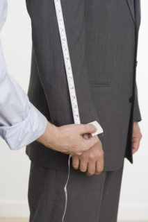 Tailor taking suit measurements.