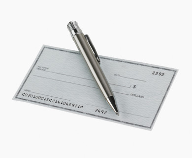 Studio shot of blank check and pen.