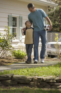 Father and young son with soccer ball.