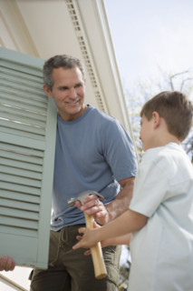 Father and young son fixing shutters.