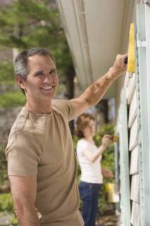 Man painting exterior of house.