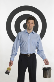 Man painting bull’s eye on wall.
