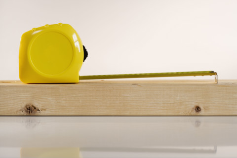 Studio shot of tape measure and wood.