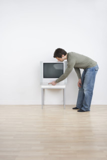 Man turning on television.