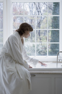 Woman in robe drawing bath.
