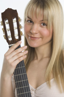 Studio shot of woman with guitar.
