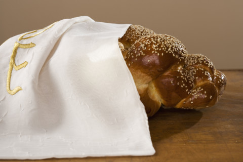 Loaf of Challah bread under cloth.